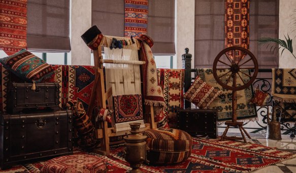 side view of a traditional rug being woven on a carpet vertical loom oriental background